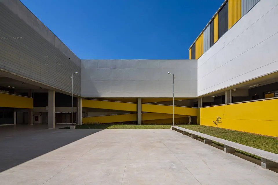 Um pátio vazio entre dois edifícios com paredes amarelas.