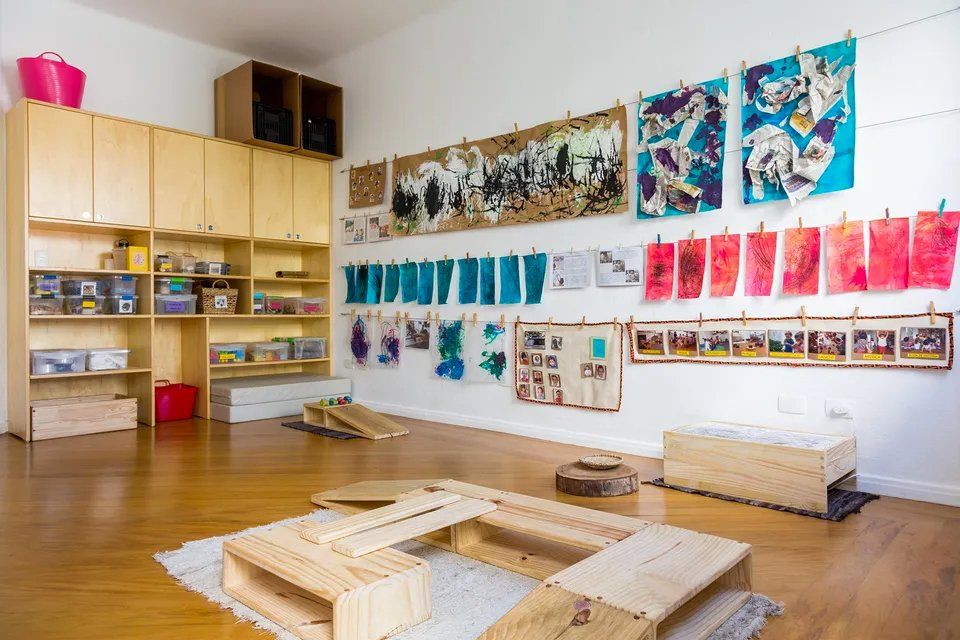Uma sala com muitos quadros na parede e uma mesa de madeira.