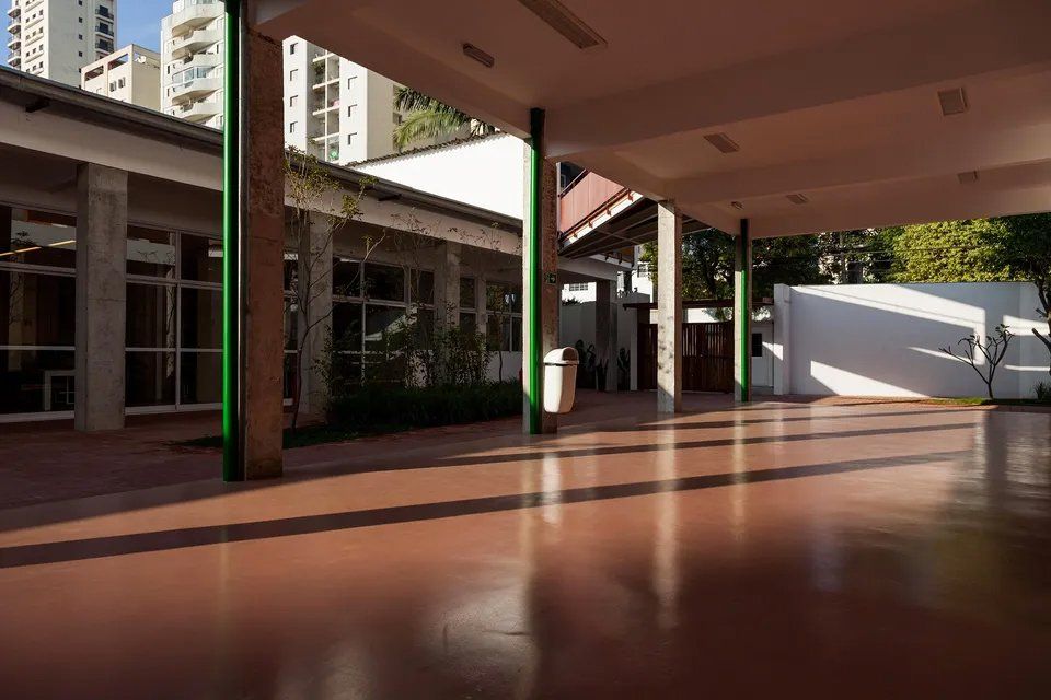 Uma grande sala vazia com um poste verde no meio