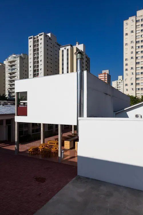 Um prédio branco com uma chaminé ao lado