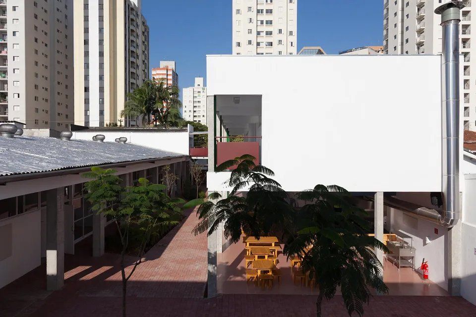 Um prédio branco com um pátio na frente