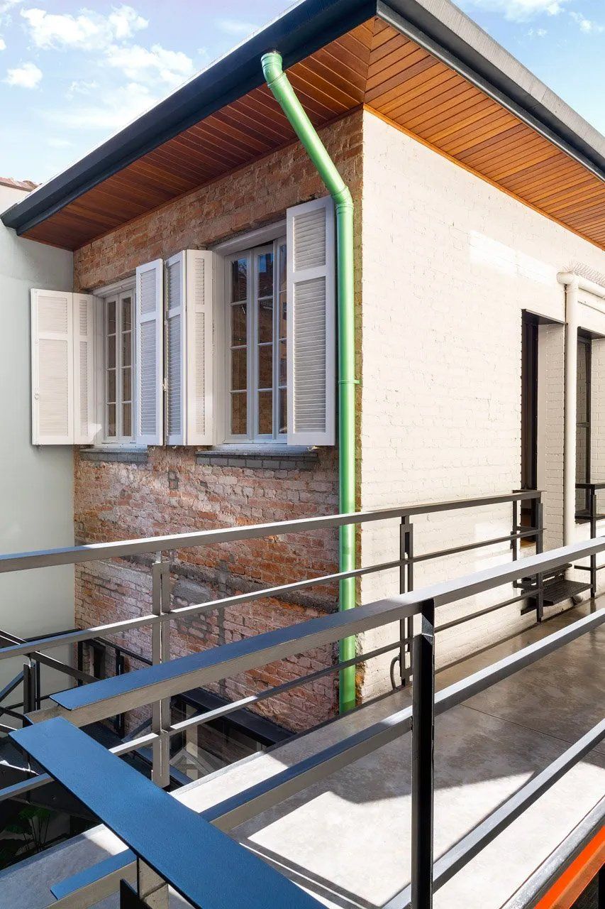 Uma casa com varanda e um cano verde