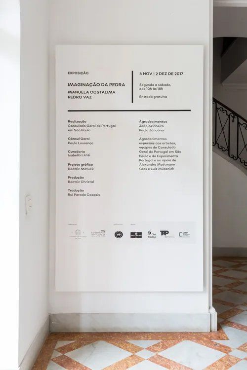 Uma placa branca em uma parede com uma escada ao fundo