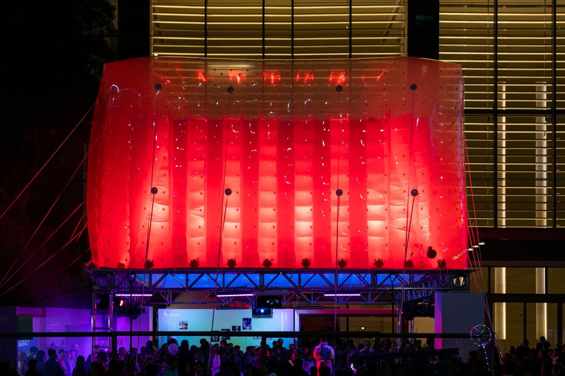 Um grande edifício com muitas luzes acesas à noite.