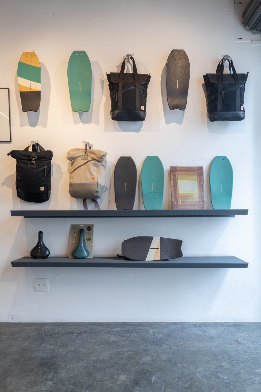 Uma parede com um monte de bolsas e skates
