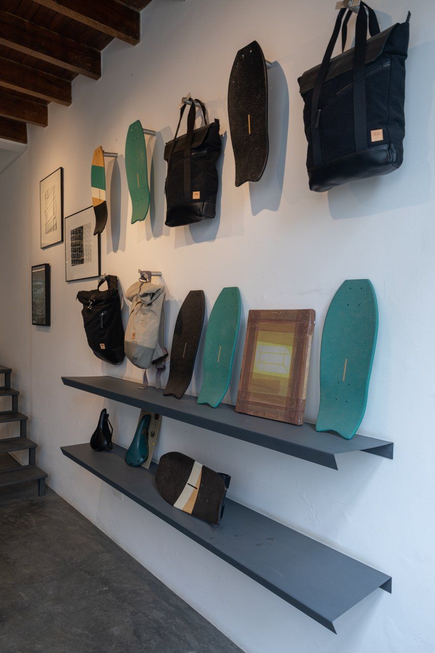 Uma parede com um monte de bolsas e skates