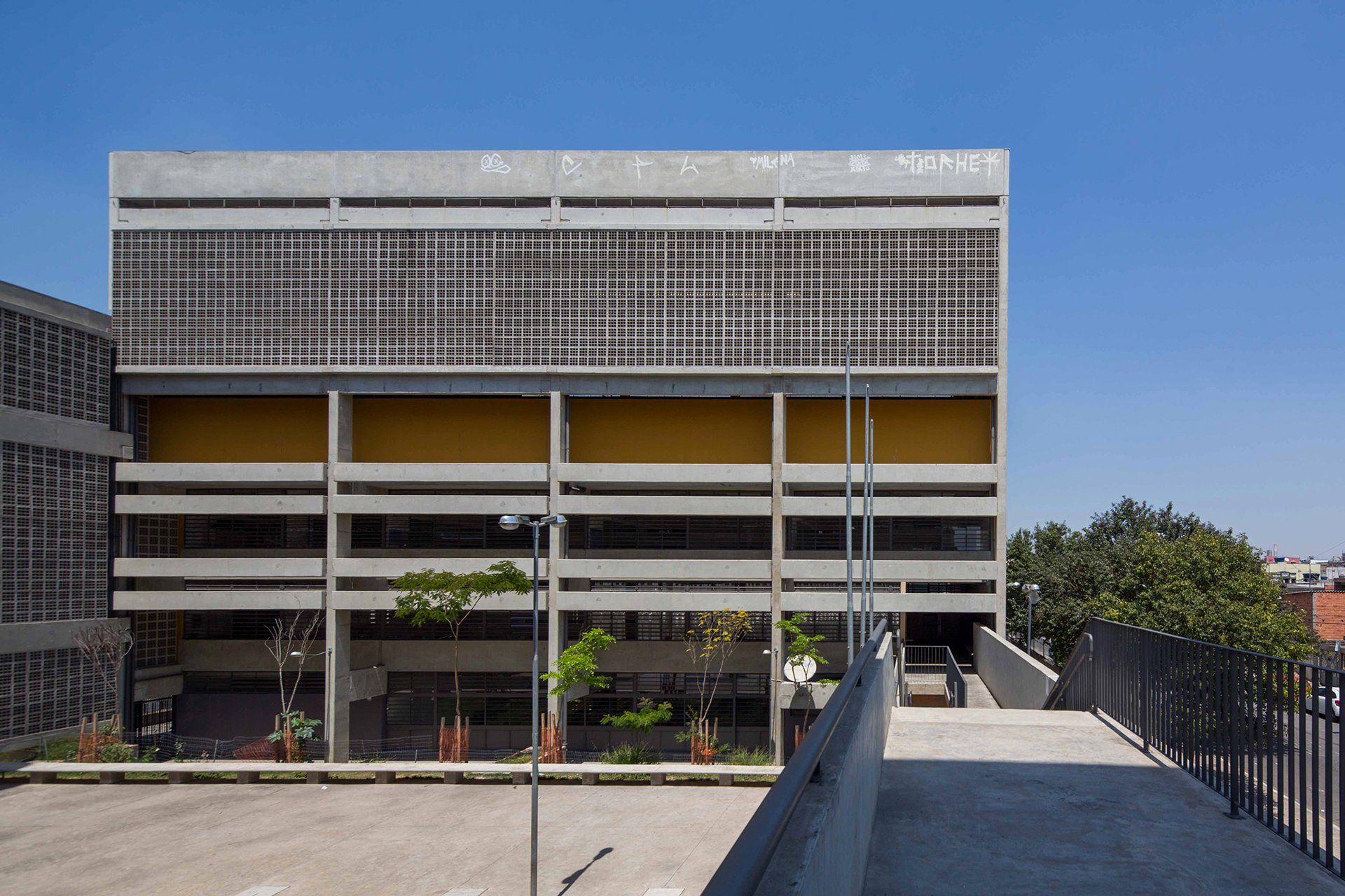 Um grande edifício com muitas janelas e uma passarela que leva até ele