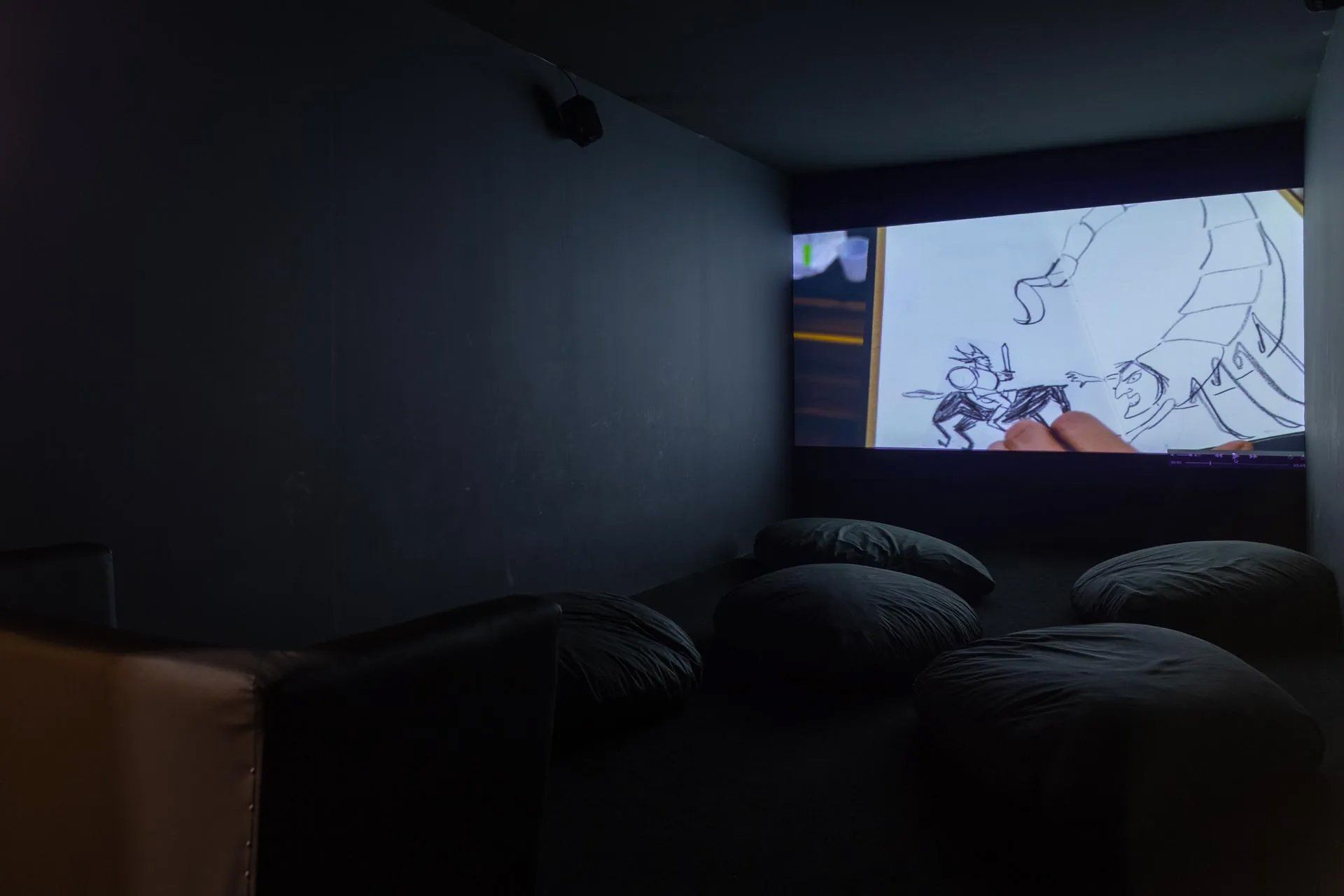 Uma sala escura com uma tela de projetor e um desenho