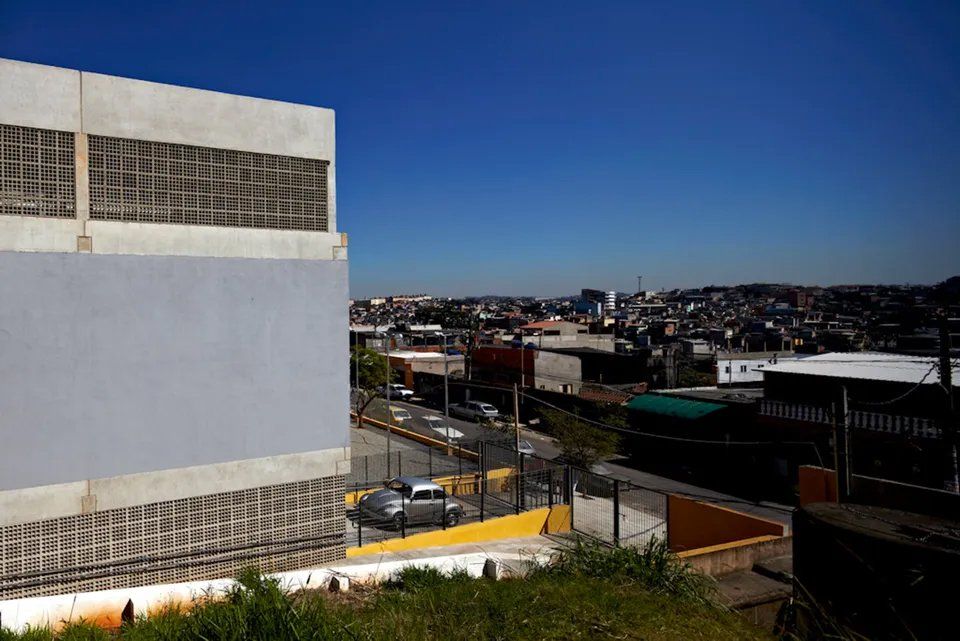 Uma vista de uma cidade a partir de uma colina com um edifício em primeiro plano.