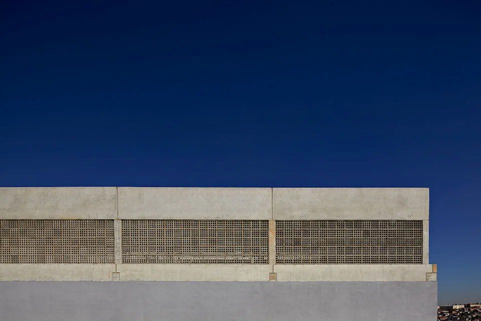 Um prédio branco com um céu azul ao fundo.