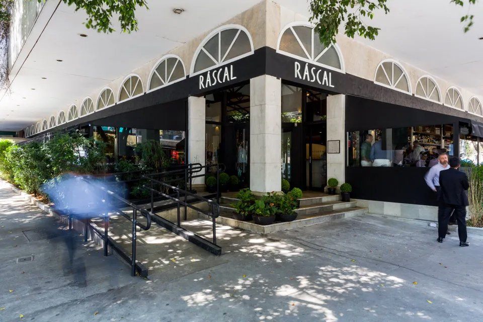 Um restaurante chamado malandro está localizado na esquina de um prédio.