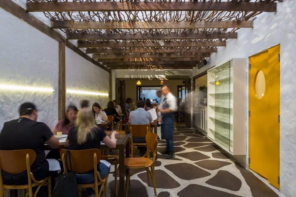 Um grupo de pessoas está sentado às mesas de um restaurante.