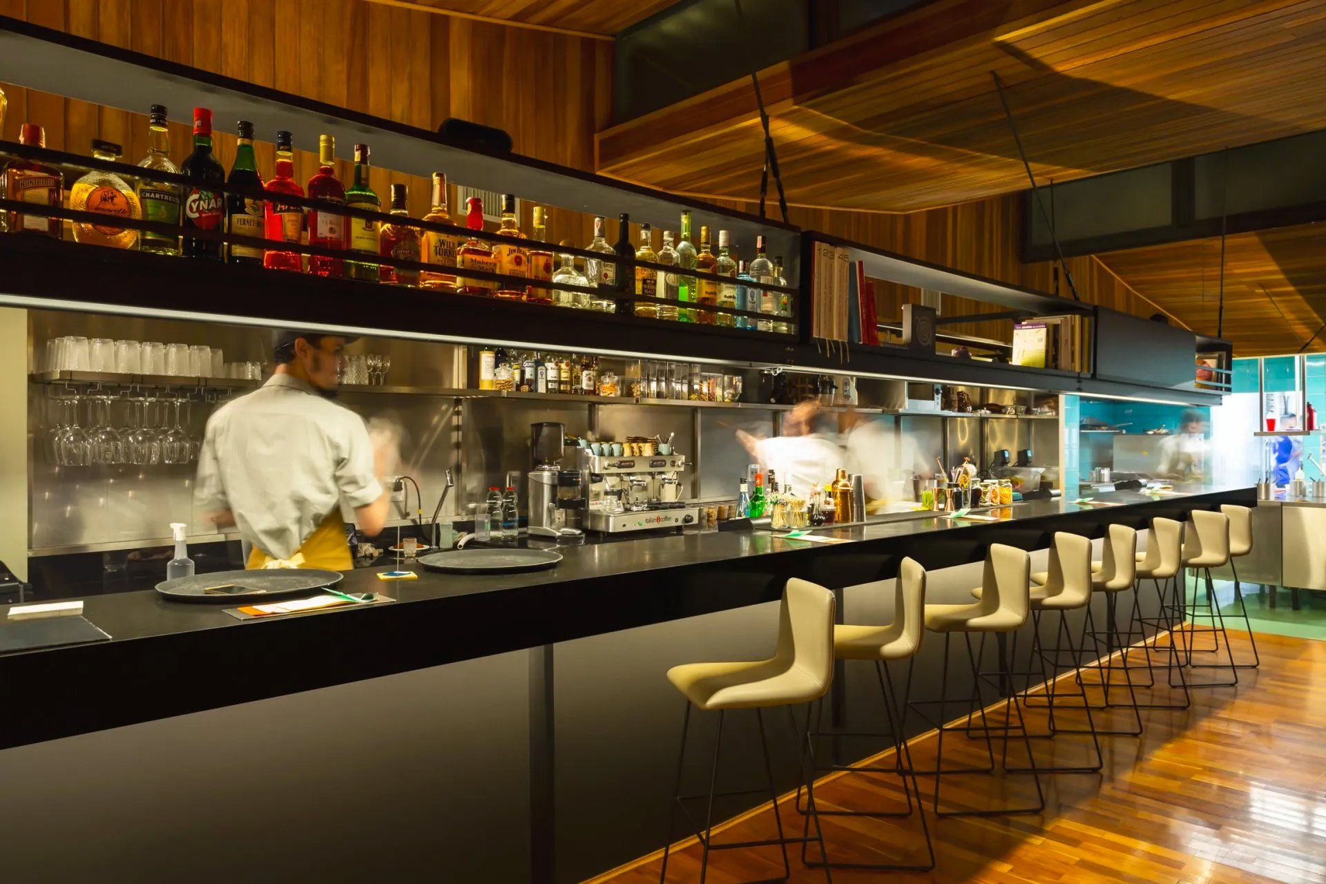 Uma cozinha de restaurante com um longo bar e bancos