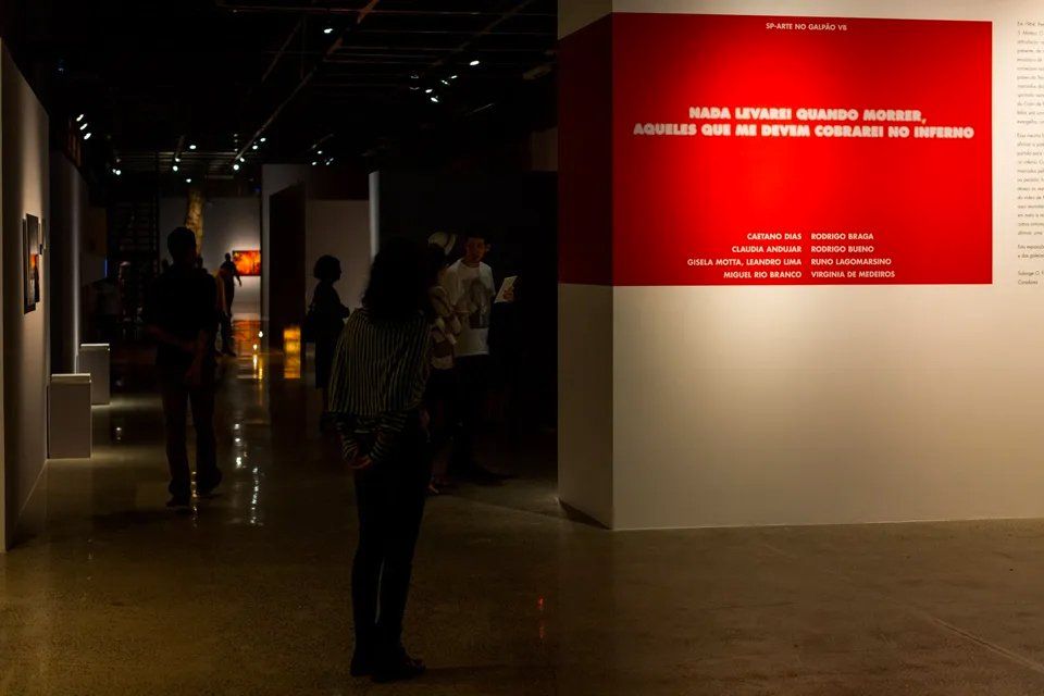 Um grupo de pessoas em frente a uma parede vermelha que diz 'águilas'
