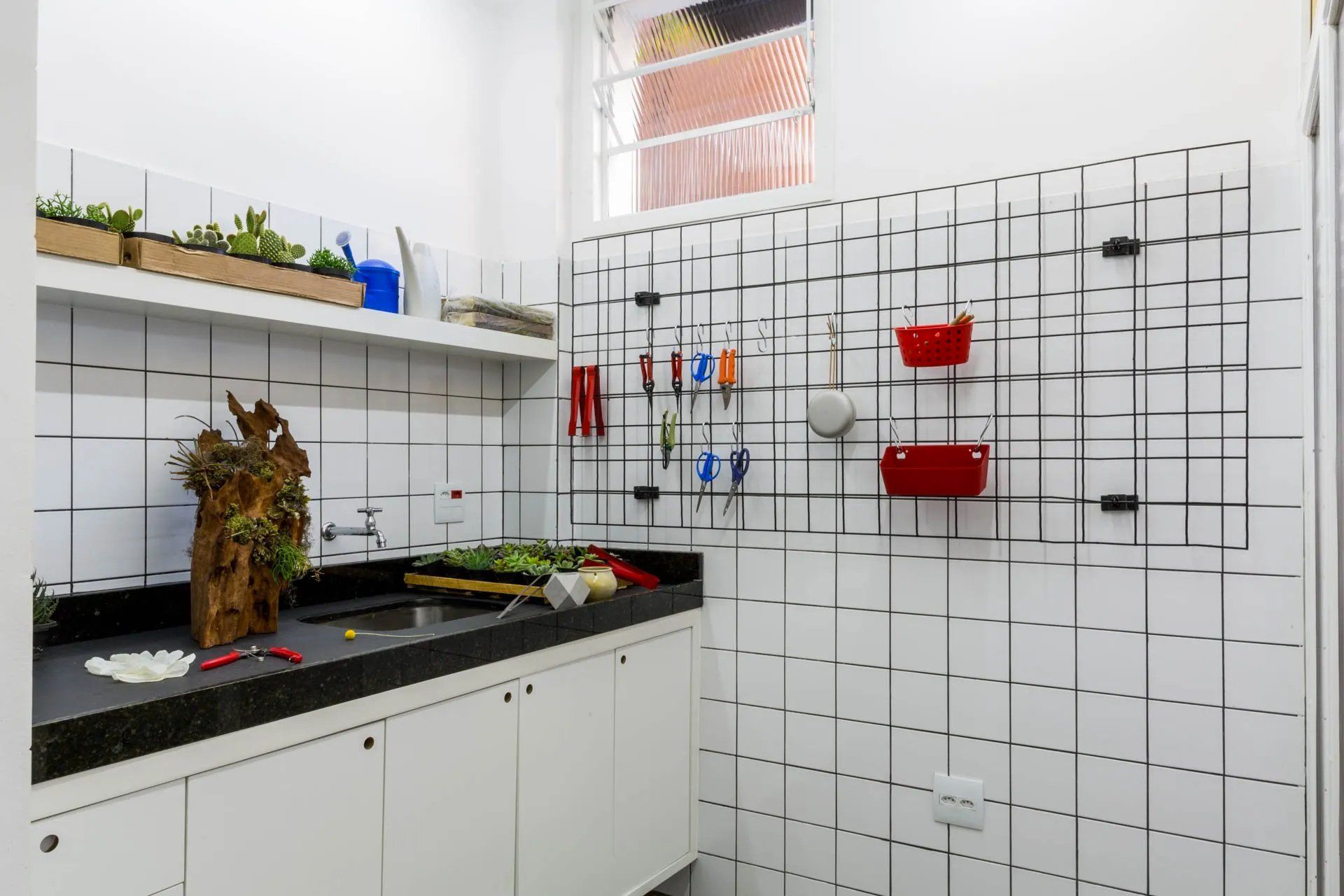 Uma cozinha com pia, armários e grade na parede.