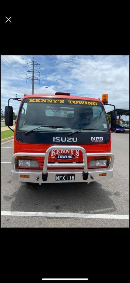 A Man is Standing Next to a Tow Truck With a Car on It — Kenny's Towing in Jensen, QLD