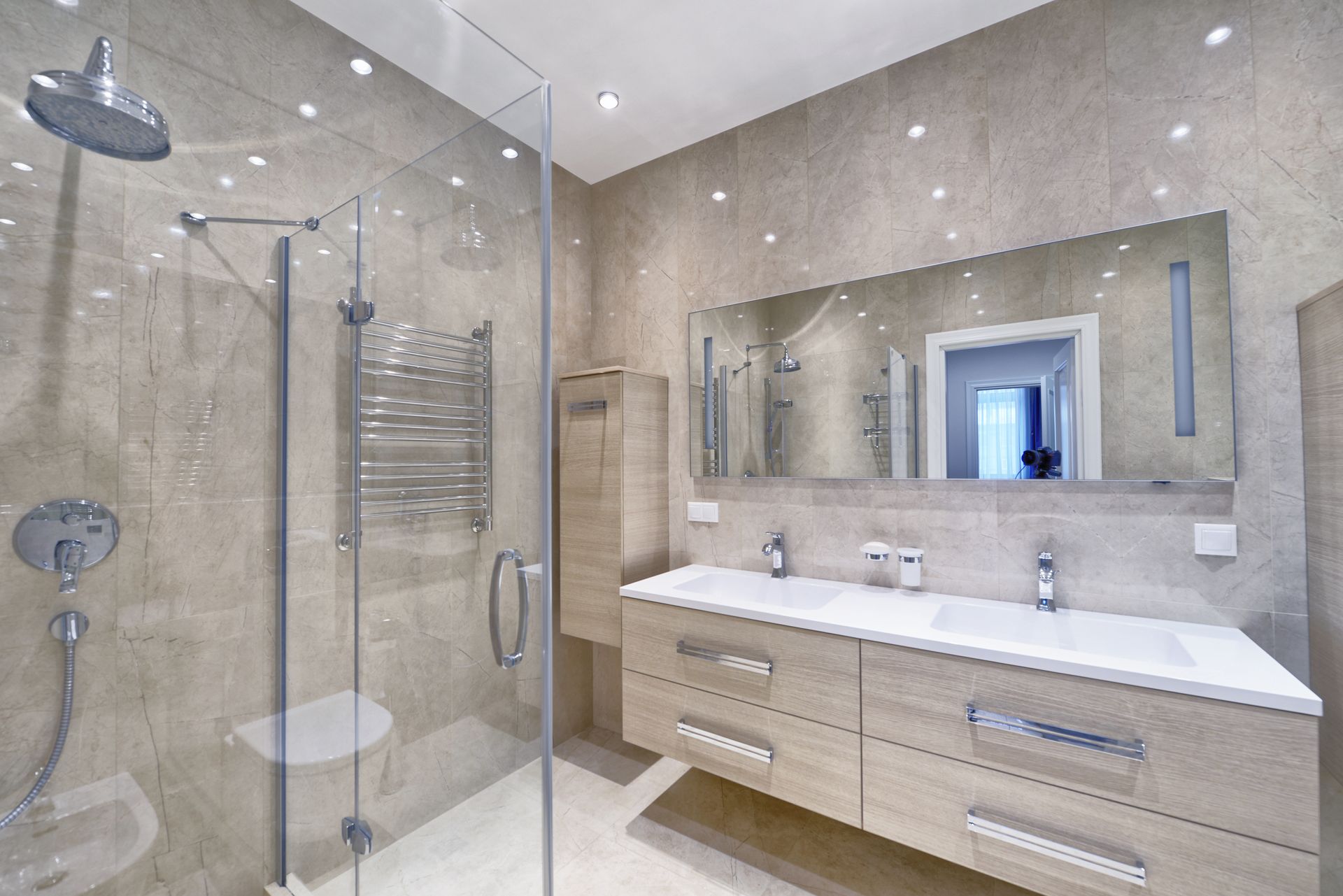 Modern beige bathroom with glass shower, vanity, mirror, and towel warmer Modern beige bathroom with glass shower, vanity, mirror, and towel warmer