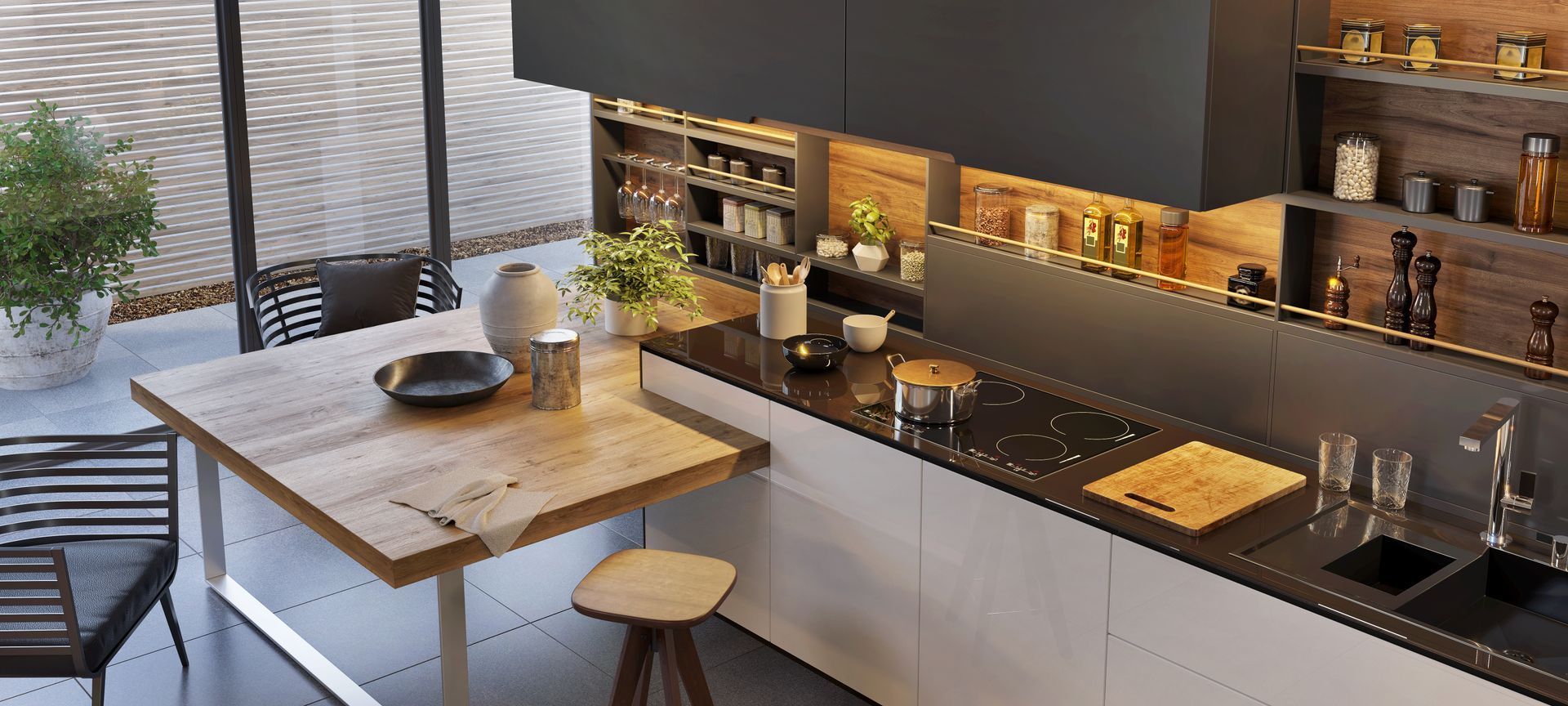 Modern kitchen with island table, dark countertops, and warm under-cabinet lighting
