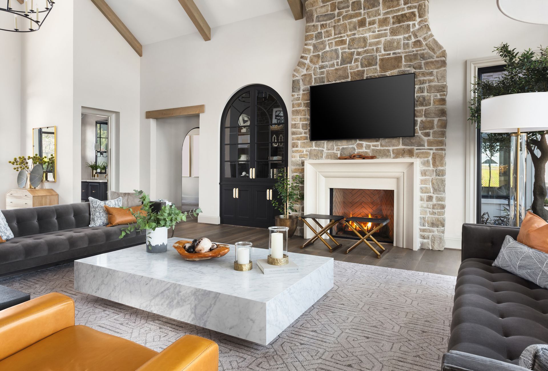 Modern living room with stone fireplace, TV, gray sofas, and a marble coffee table Modern living room with stone fireplace, TV, gray sofas, and a marble coffee table