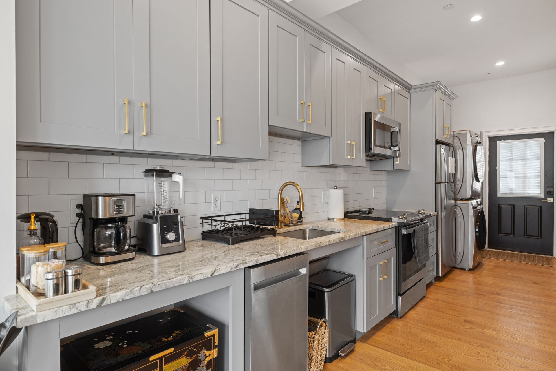 Modern kitchen with gray cabinets, granite counters, stainless appliances, and wood floors. Modern kitchen with gray cabinets, granite counters, stainless appliances, and wood floors.