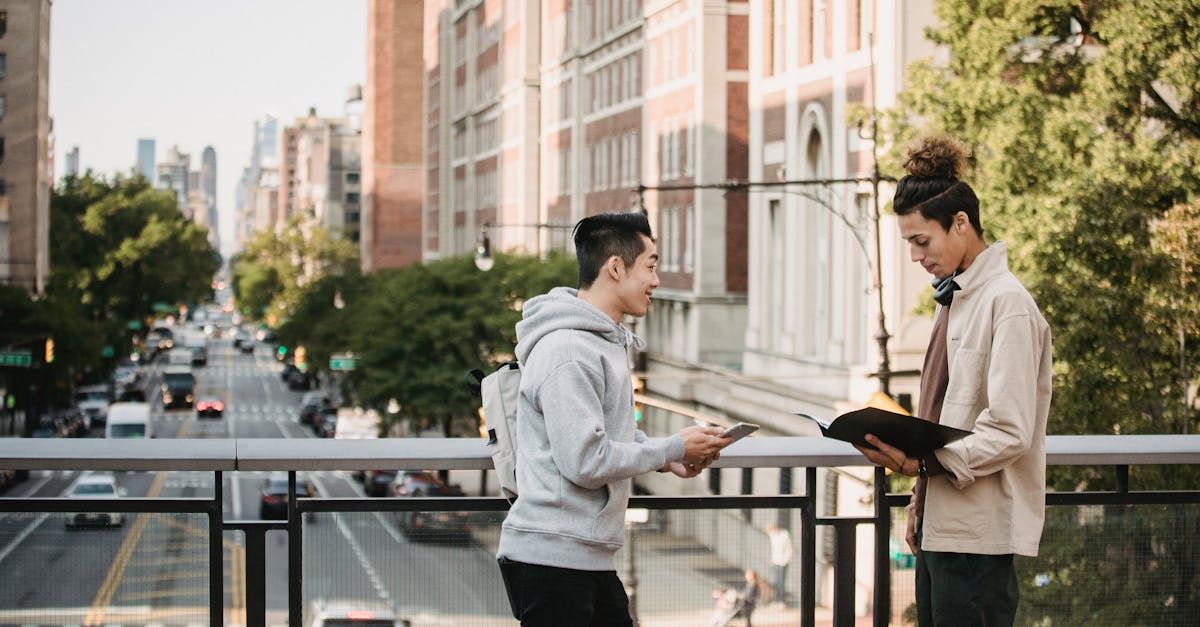 Two men are standing on a bridge looking at a bible.