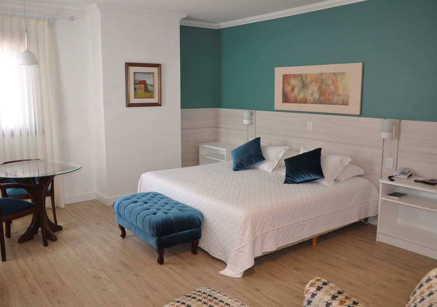 um quarto de hotel com cama king size, mesa e cadeiras.