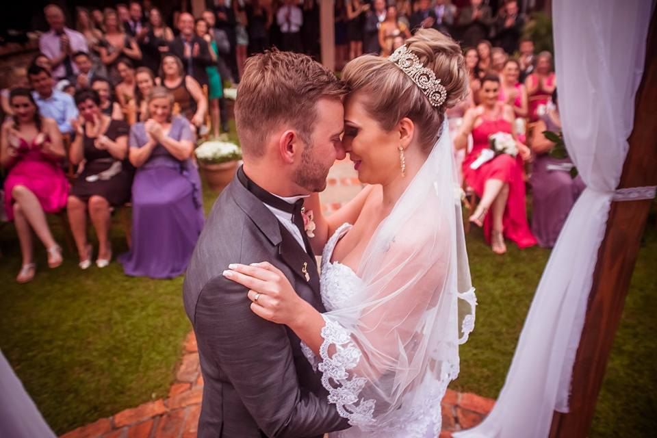 os noivos se beijam na frente dos convidados do casamento.