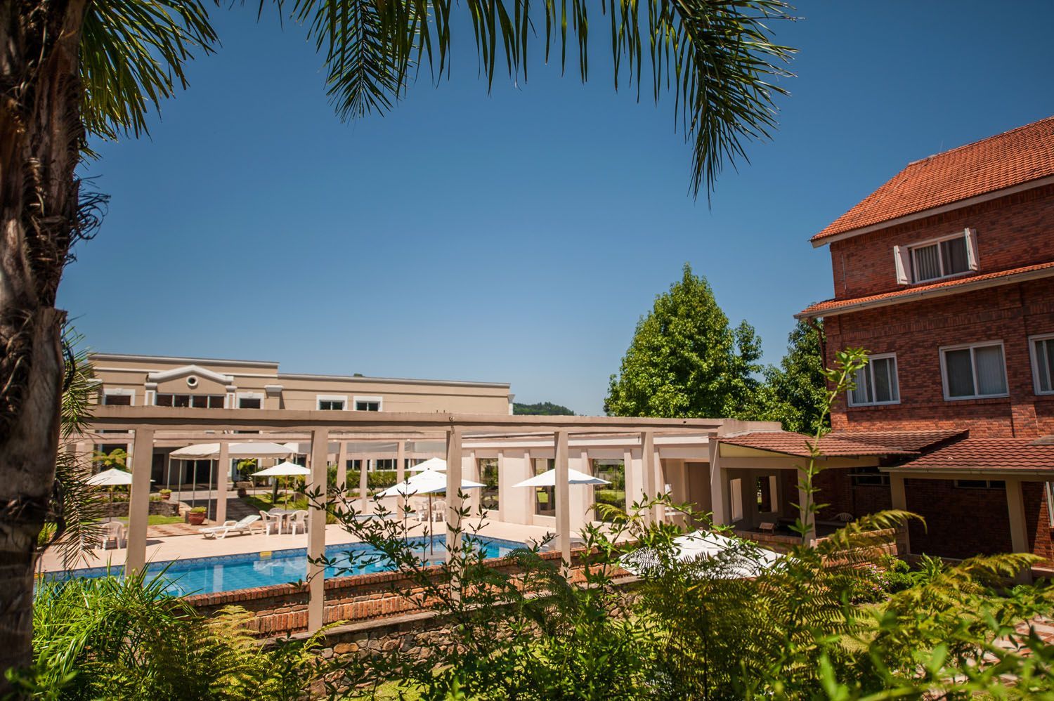 um grande edifício de tijolos com uma piscina em frente.
