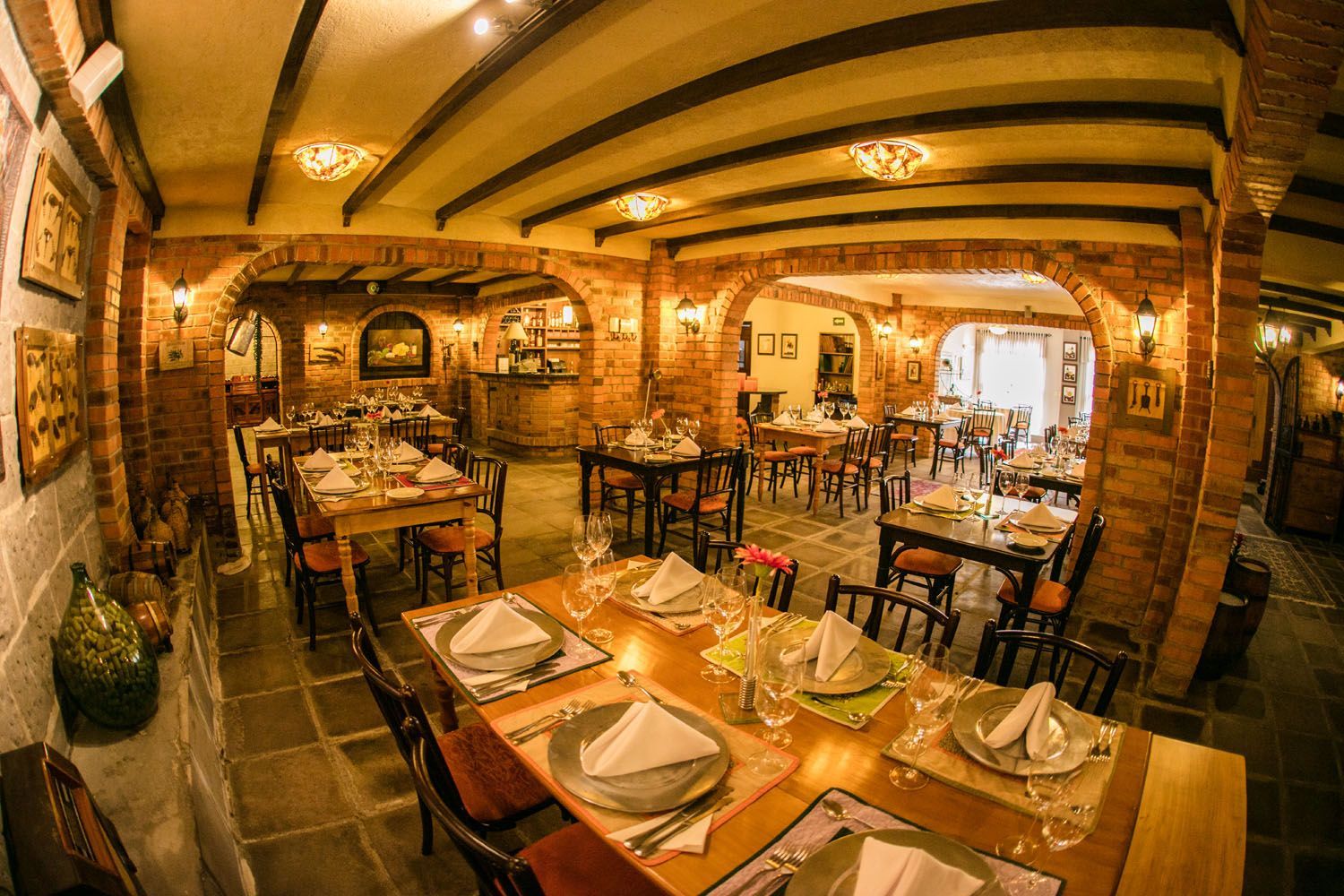 um restaurante com mesas e cadeiras preparadas para uma refeição.