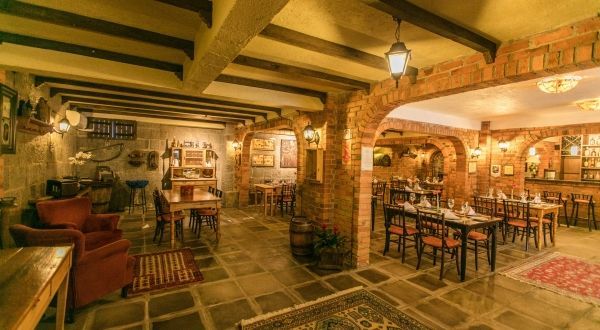 um restaurante com mesas e cadeiras em um prédio de tijolos.