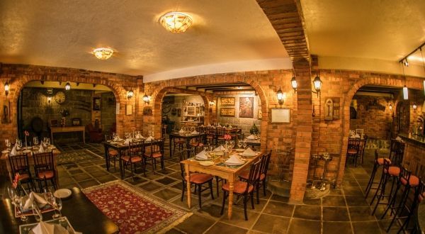 um restaurante com mesas e cadeiras em um prédio de tijolos.