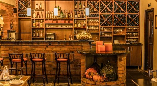 um restaurante com bar e bancos e lareira.
