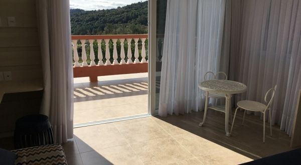 um quarto com mesa e cadeiras e varanda.