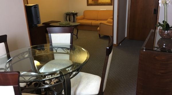 uma sala de estar com mesa e cadeiras de vidro