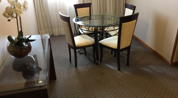 uma sala de estar com mesa e cadeiras de vidro