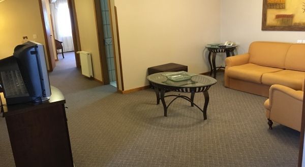 uma sala de estar com sofá, mesa e televisão