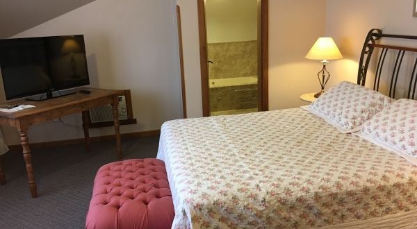 um quarto com cama king size e TV de tela plana