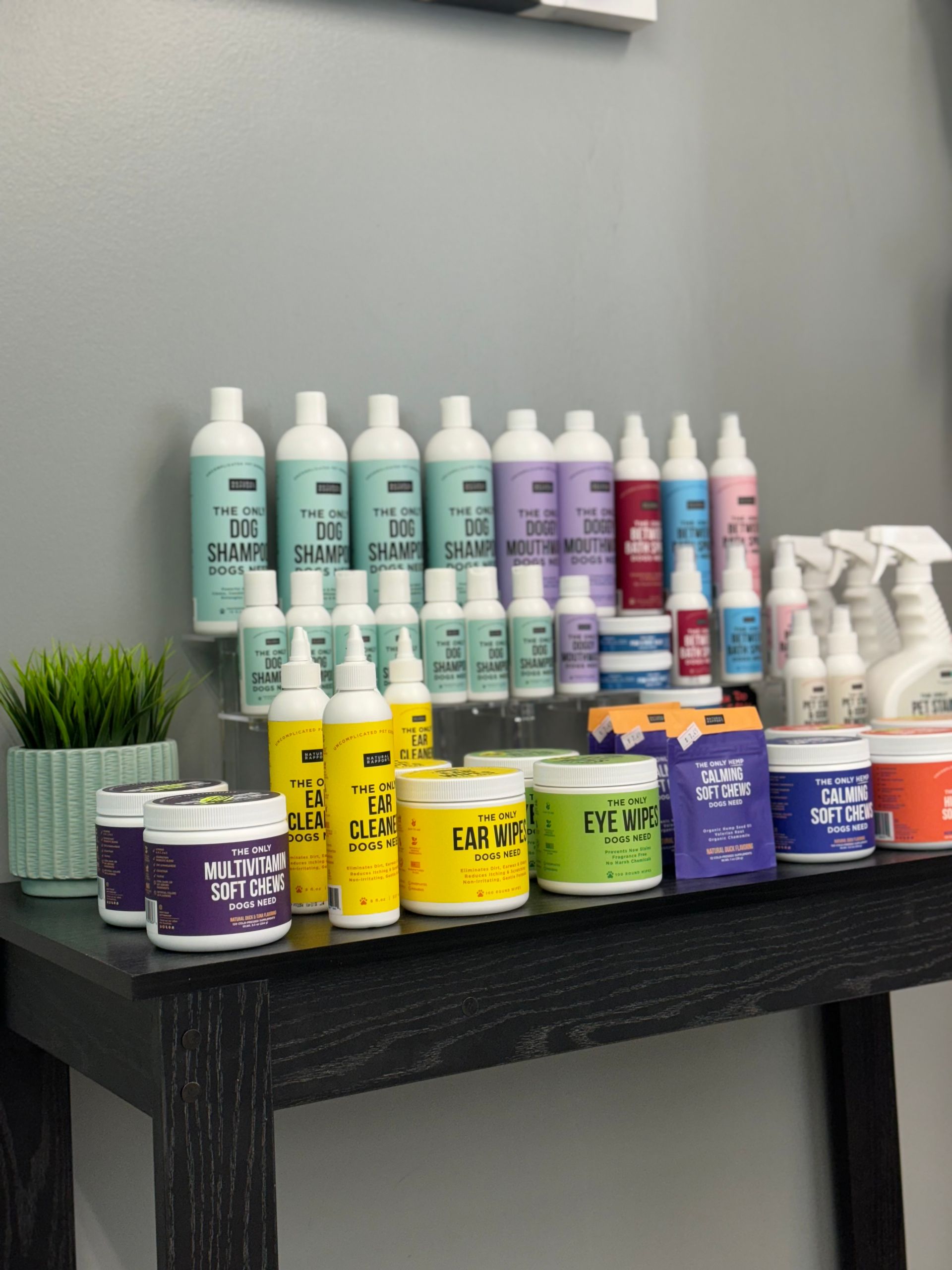 A bunch of bottles on a table with one that says ' shampoo ' on it