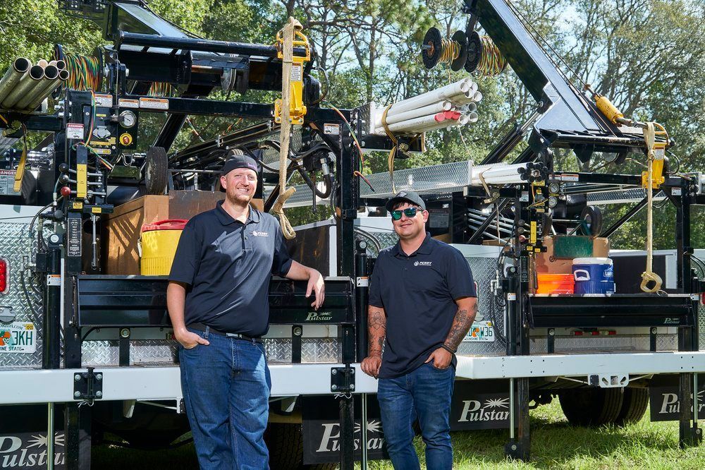 Two men are standing in front of a truck.