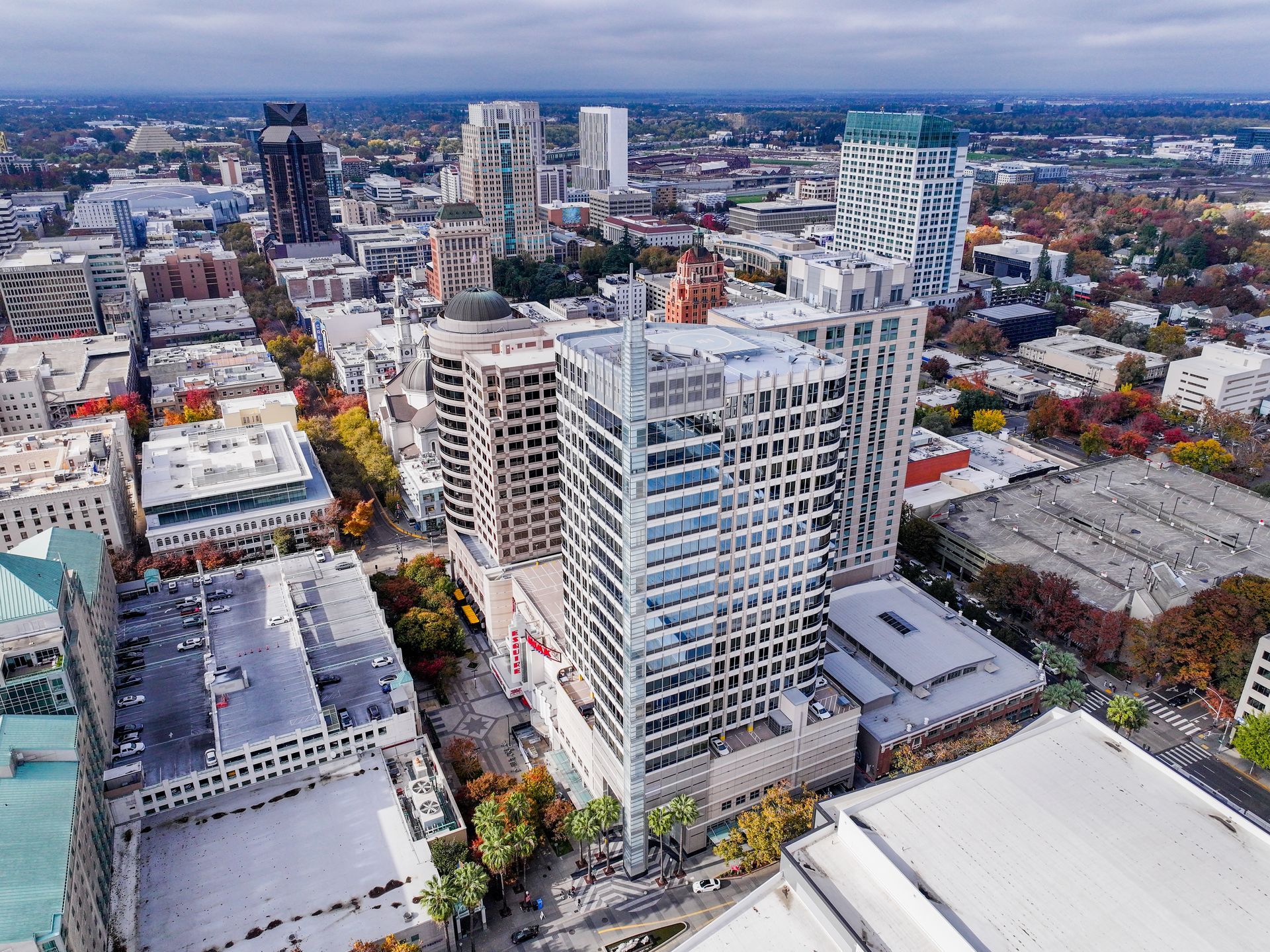 Aerial view of Sacramento, California skyline with tall buildings and autumn trees.
