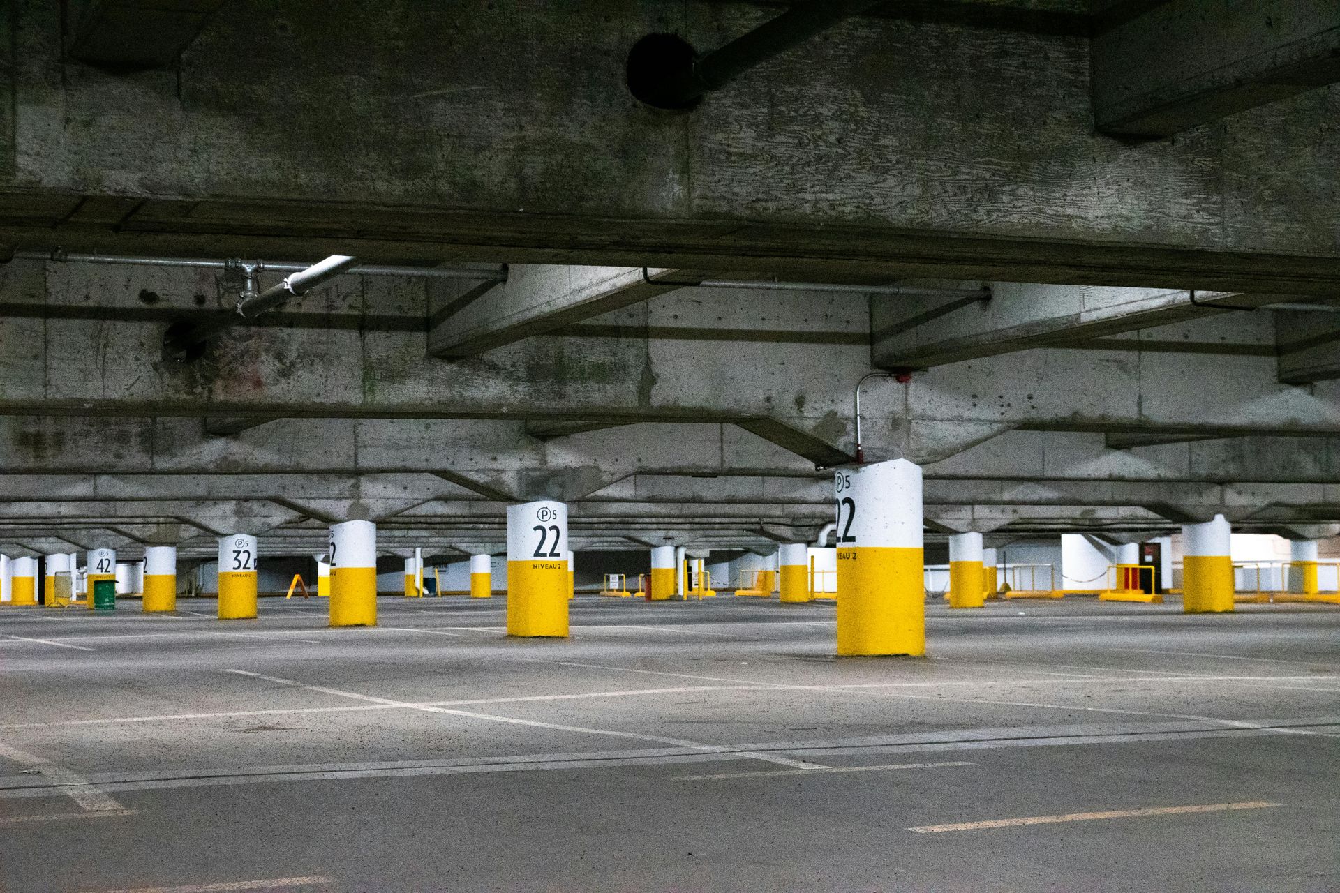 Parking garage with rows of yellow and white support columns.
