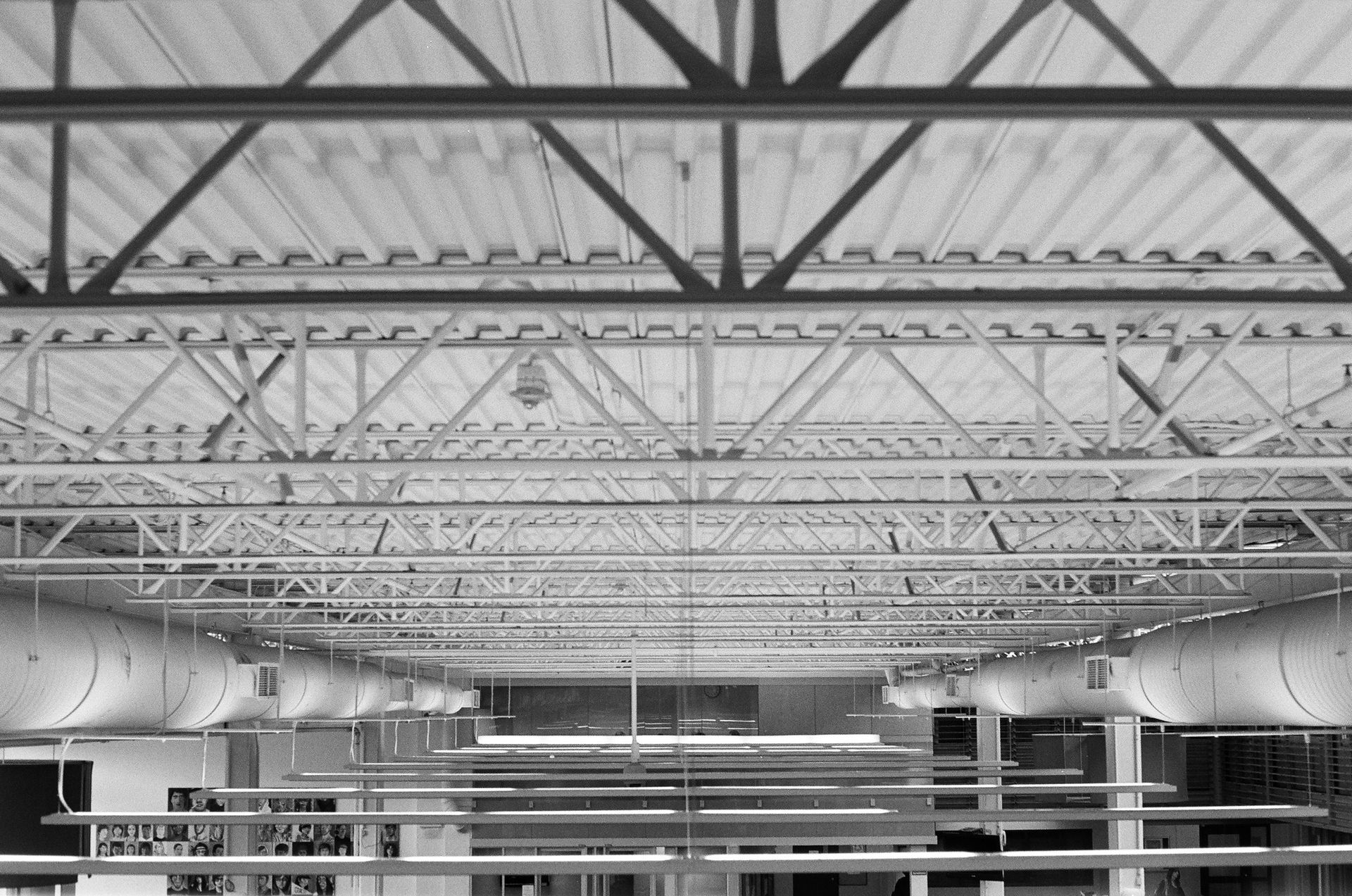 Overhead view of a metal roof structure with support beams and ventilation ducts.