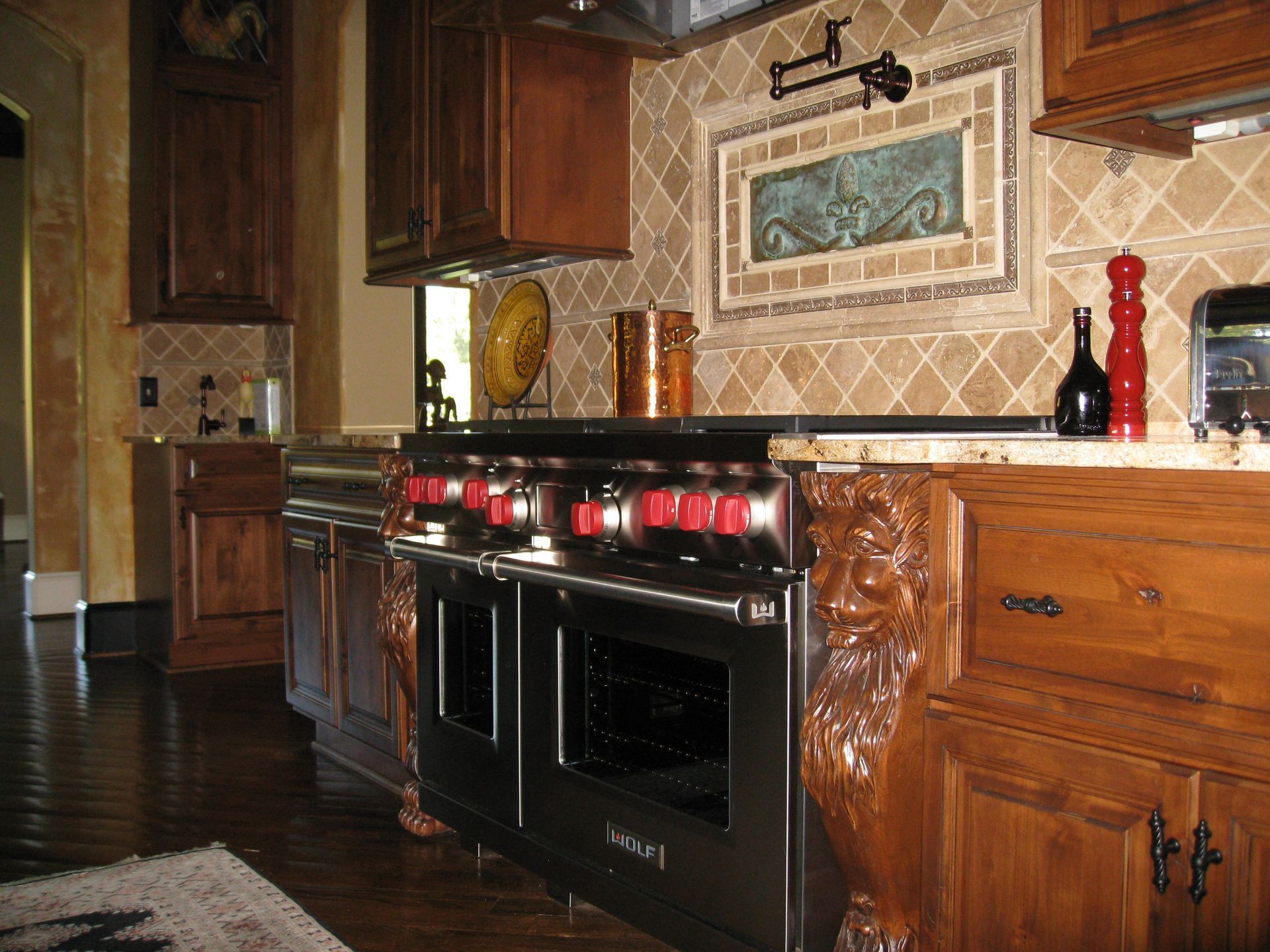 Luxury kitchen with dark wood cabinets, black stove, beige tile backsplash, and granite countertops