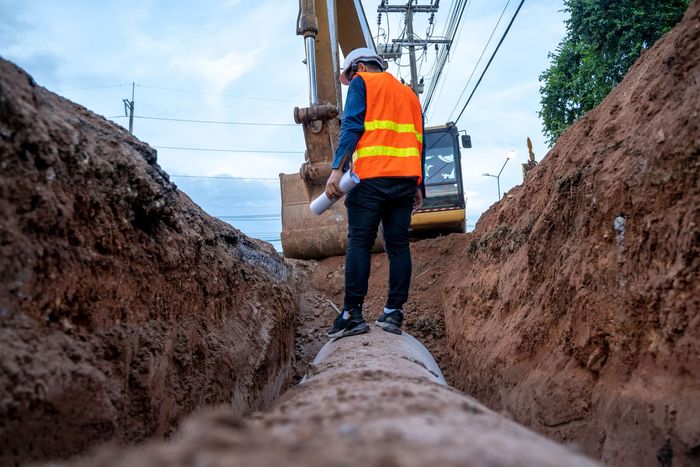 Engineer standing on a pipe