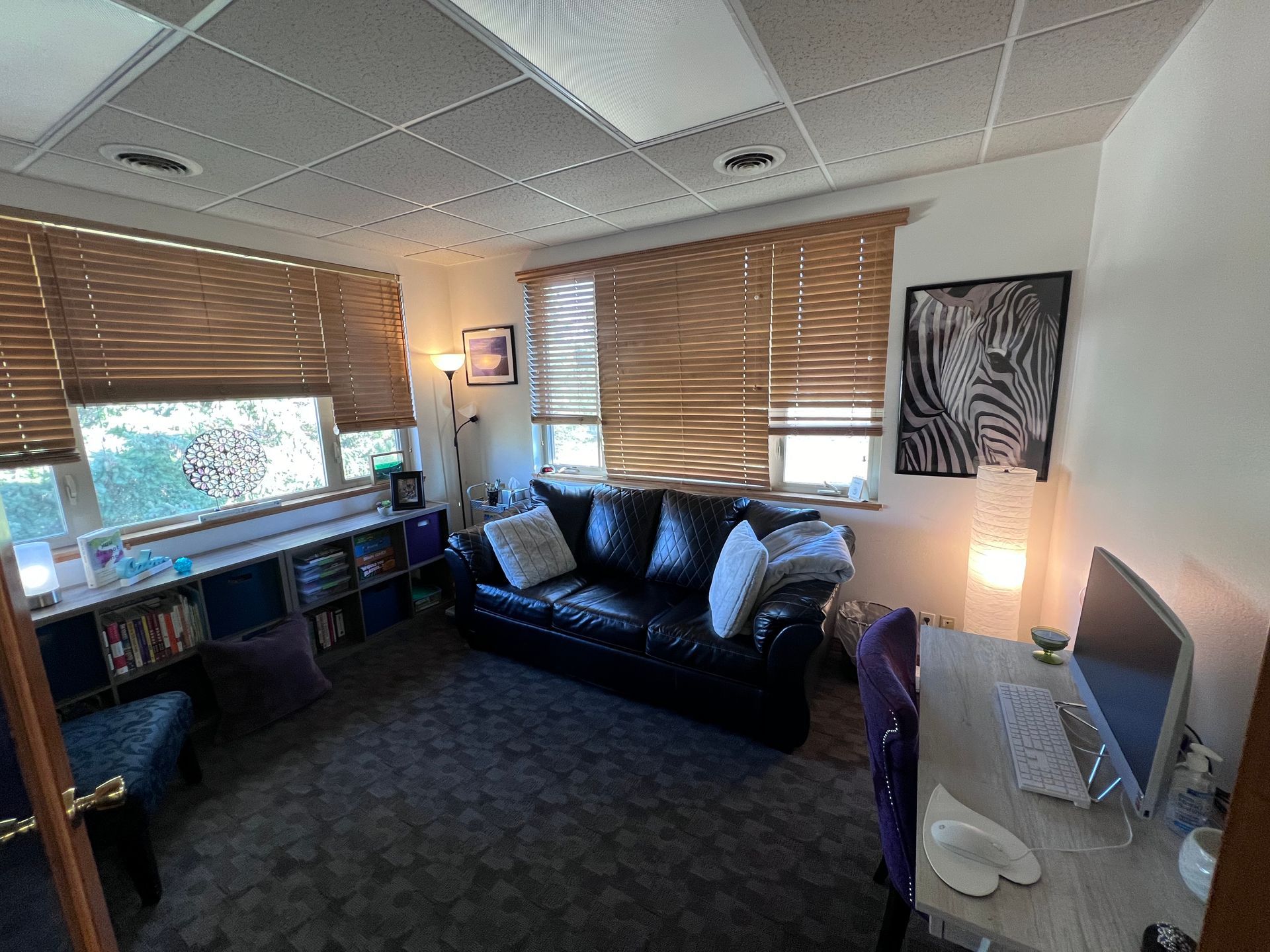 A living room with a couch , desk and computer