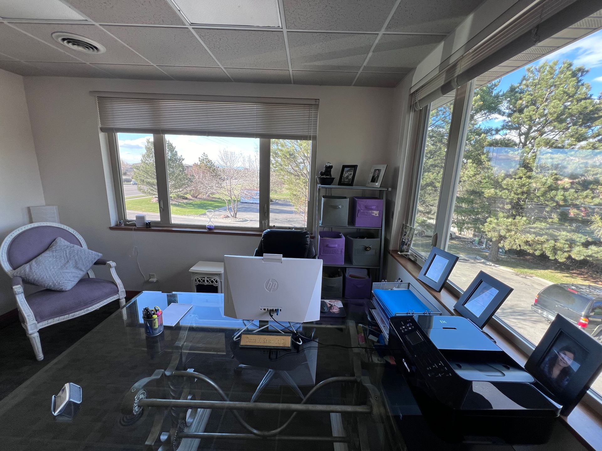 A room with a desk , chair , computer and printer.