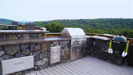 Outdoor Kitchen There is a grill on the roof of a house with a view of the mountains.