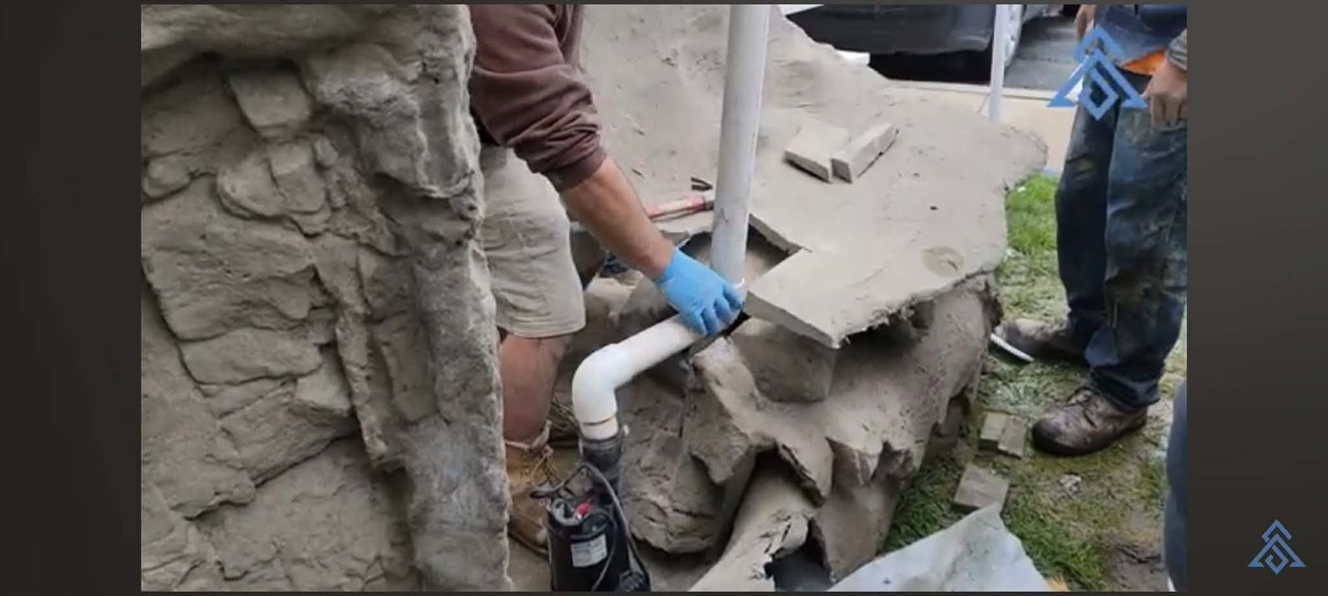 Worker in blue gloves filling a cracked concrete statue with white foam outdoors