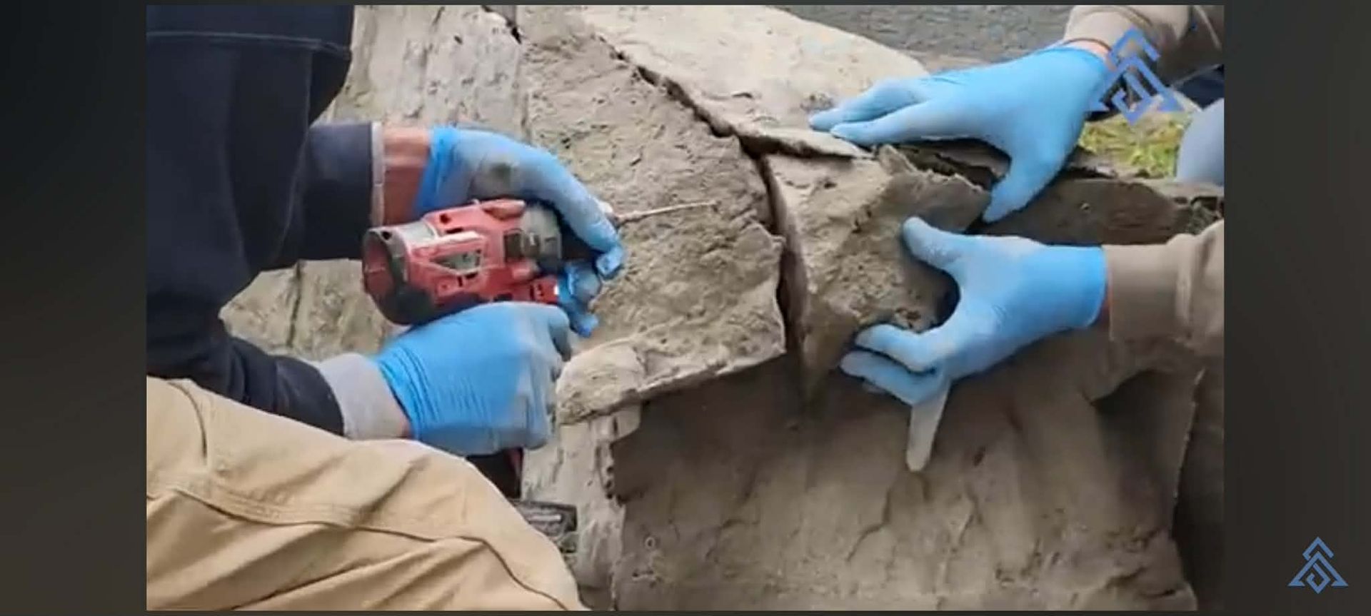 Hands mixing gray cement in a round basin outdoors