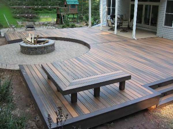 A wooden deck with a fire pit and a bench